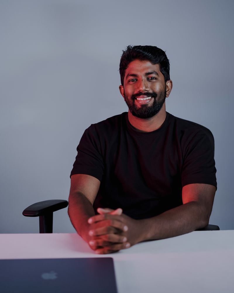 Shabeeb Nattukal at his desk with a laptop, smiling